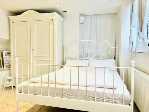 1 dormitorio blanco con 1 cama blanca y armario en Studio am Waldbach en Gernsbach