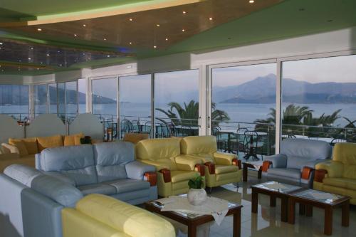 a living room with couches and tables and windows at Princessa Riviera Resort in Pythagoreio