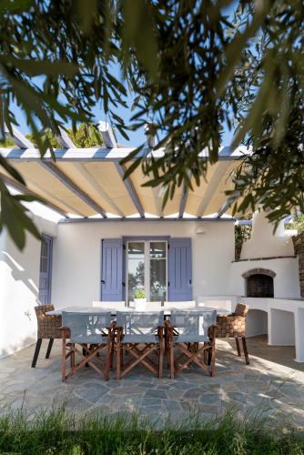 a table and chairs in front of a house at Orasea Villa with private pool in Parikia