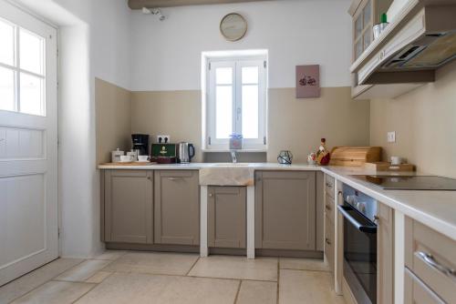 a kitchen with a sink and a window at Orasea Villa with private pool in Parikia