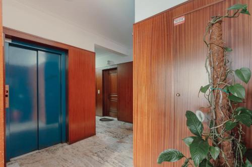 un pasillo con una puerta y una planta en Rising Sun Apartment en Leça da Palmeira