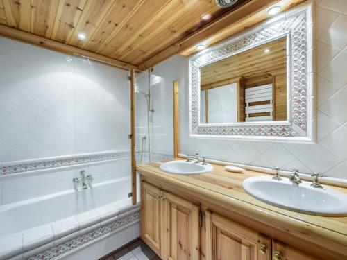 a bathroom with two sinks and a tub and a mirror at Chalet Courchevel 1650, 7 pièces, 12 personnes - FR-1-563-17 in Courchevel