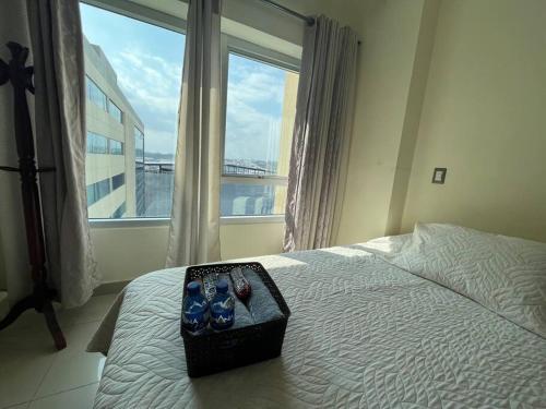 a bedroom with a bed with a pair of shoes on it at Coffee Suite, wifi, Parqueo, gym & piscina! in Guayaquil