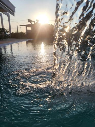 a water fountain with the sun setting in the background at Callista Suites in Flogita