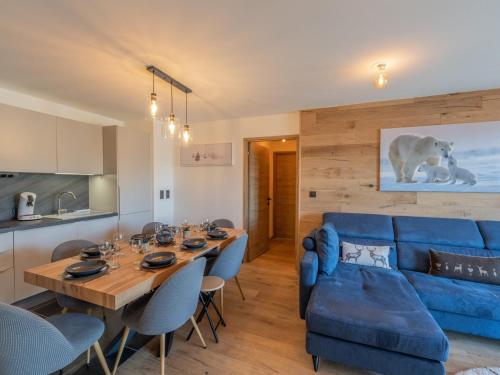 un salon avec un canapé bleu et une table dans l'établissement Appartement neuf, 3 ch., 8 pers., cabine, au pied des pistes à Courchevel - FR-1-563-112, à Courchevel