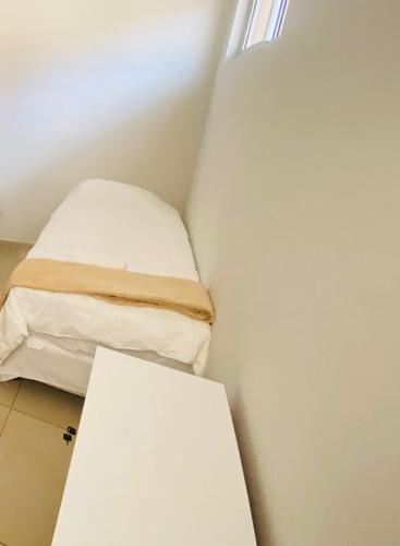 a small room with a bed and a table at Hotel Santorine Prime - Itabira in Itabira