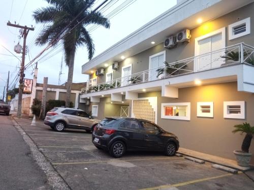 dos autos estacionados en un estacionamiento frente a un edificio en Smart Hotel, en Registro