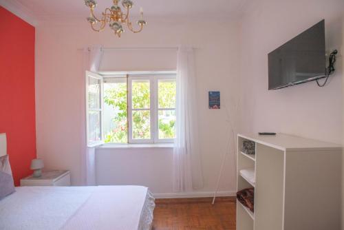 a bedroom with a bed and a window at Hostel das Flores in Senhora da Hora