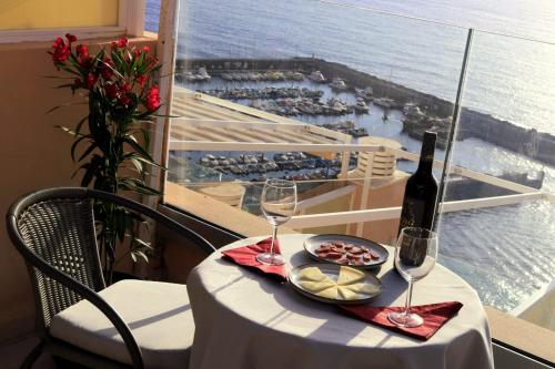 a table with a bottle of wine and glasses on a balcony at Buenavista in Acantilado de los Gigantes