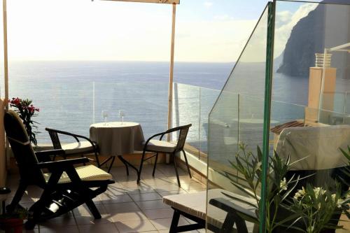 a balcony with a table and chairs and the ocean at Buenavista in Acantilado de los Gigantes