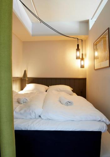 a bedroom with two beds with white sheets at Nordlandet in Allinge