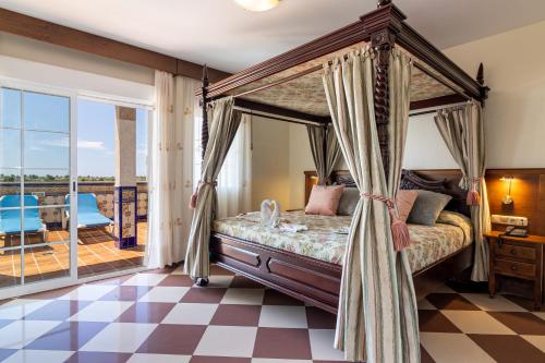 ein Schlafzimmer mit einem Himmelbett und einem karierten Boden in der Unterkunft Hotel Avenida Tropical by Bossh! Hotels in Salobreña