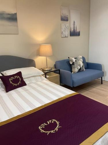 une chambre avec un lit et un canapé bleu dans l'établissement Luxury One bedroom with garden, à Vallauris