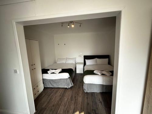 mały pokój z 2 łóżkami i lustrem w obiekcie The Ruislip Apartment w mieście Ruislip