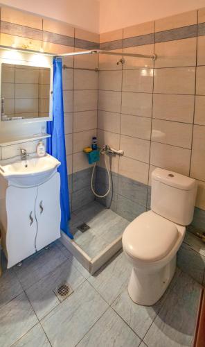 a bathroom with a toilet and a sink and a shower at Gallery Suites ''Athina'' in Missolonghi