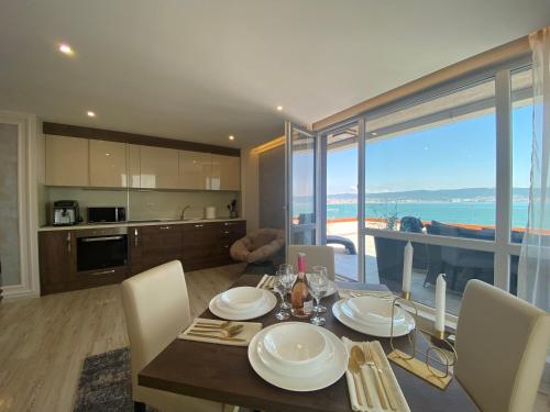 a dining room with a table and a kitchen with a view at PARADISO 607 Large Luxury Apartment in Nesebar