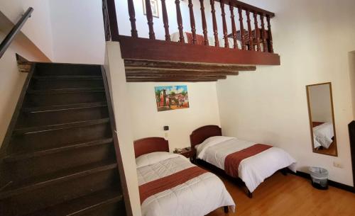 2 camas en una habitación con escalera en Hotel Cusco Plaza Saphi, en Cusco