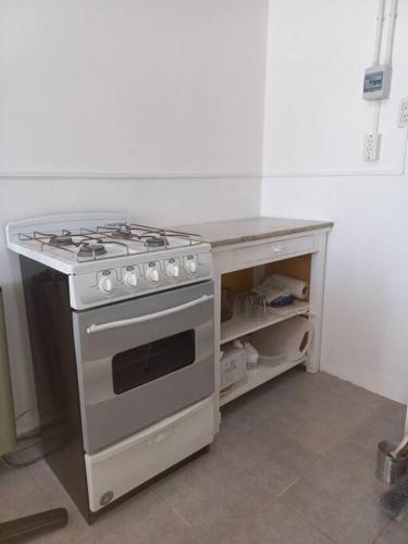 a kitchen with a stove and a counter top at Departamento impecable. con cochera in Luján
