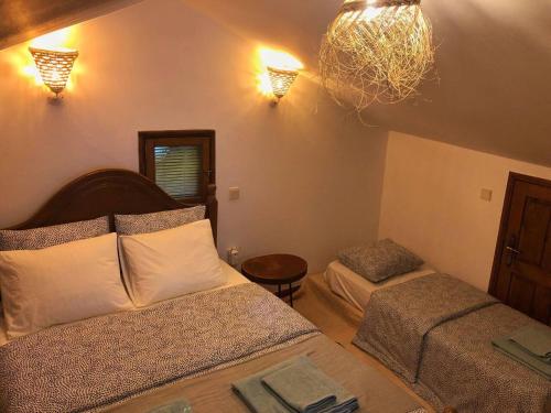 a bedroom with two beds and a chandelier at Casa Maria in Terras de Bouro