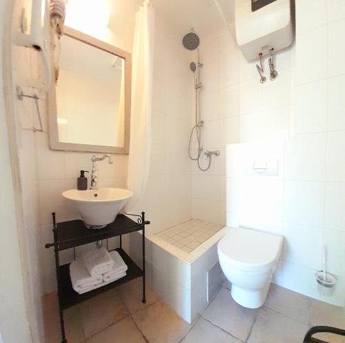 a white bathroom with a sink and a toilet at Apartments Martin in Vis