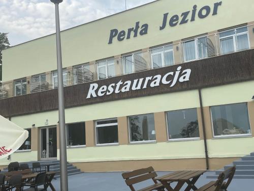 a building with a sign for a restaurant at Perła Jezior in Ruciane-Nida
