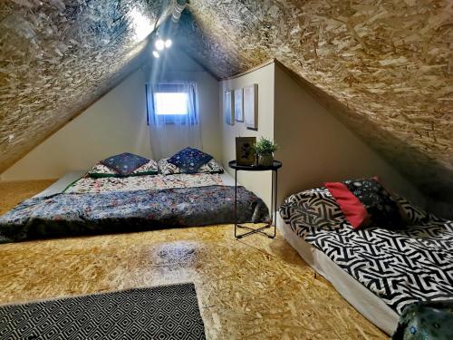 - une chambre mansardée avec 2 lits et un mur en pierre dans l'établissement Apartament od Kaszuba, à Żuromin