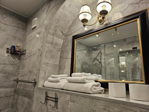 baño con espejo y toallas en la encimera en Park apartments en Rokiškis