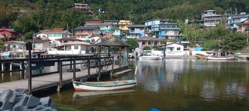 a boat is docked at a dock in a village at Pousada Porto do Torquato in Florianópolis