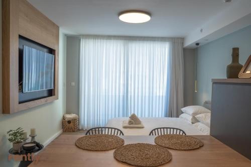 a bedroom with a bed and a table with two chairs at Sea side "Tulip" apartment - by Rently in Eilat