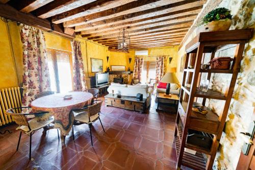 ein Wohnzimmer mit einem Tisch und einem Sofa in der Unterkunft Casa Rural Álamo Grande in Layos