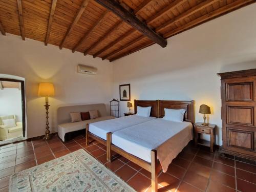 a bedroom with a bed and a couch at Convento da Provença in Portalegre