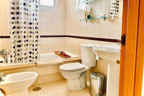 a bathroom with a toilet and a sink and a tub at Casa Algarrobo Golf - El Toyo - PN Cabo de Gata in Almería
