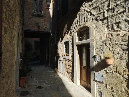 an alley in an old stone building with a door at Casa Erica in Cortona