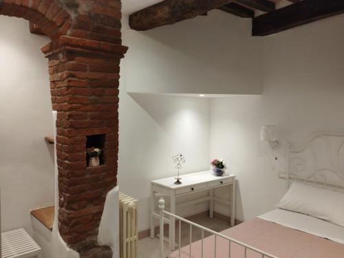 a bedroom with a bed and a brick wall at Casa Erica in Cortona
