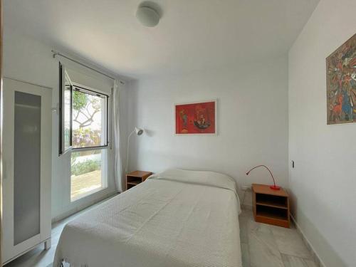 a white bedroom with a bed and a window at Casa Algarrobo Golf - El Toyo - PN Cabo de Gata in Almería