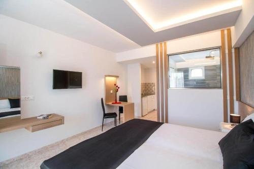 a bedroom with a bed and a desk and a tv at Casa Stavris in Faliraki