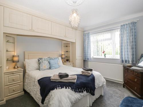 a bedroom with a large bed and a chandelier at Melita in Langport