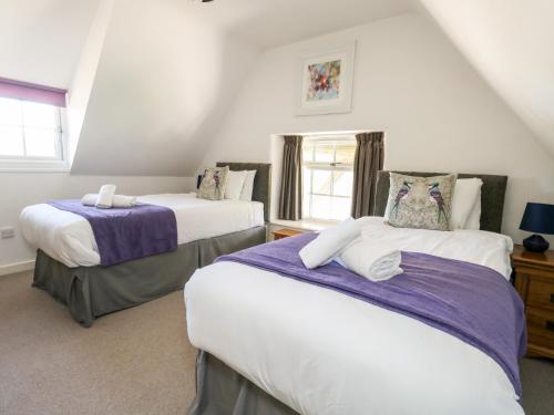 a bedroom with two beds and a window at Magnolia Cottage Osmington in Osmington