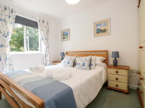un dormitorio con una cama y una ventana en Robinswood, en Falmouth
