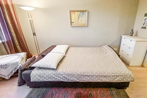 Una cama con almohadas y una lámpara en un dormitorio en Merevaatega kesklinna korter en Haapsalu