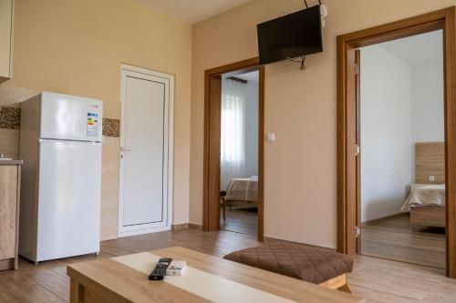 a kitchen with a refrigerator and a tv in a room at Apartments Rudaj in Ulcinj