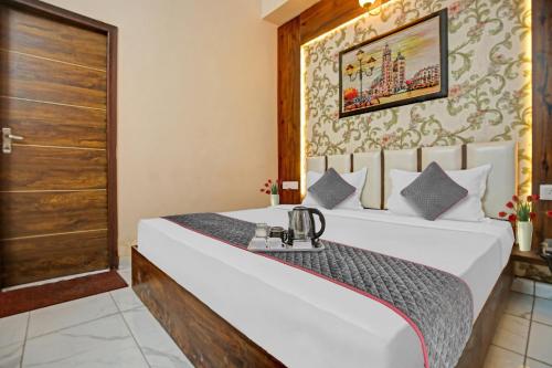 ein Schlafzimmer mit einem großen weißen Bett in einem Zimmer in der Unterkunft OYO Townhouse 1003 Hotel Sky 9 in Ludhiana