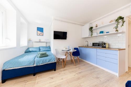 a bedroom with a bed and a small kitchen at Balaton Wave Apartments in Balatonalmádi