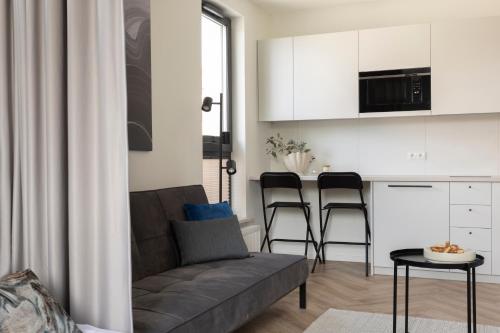 a living room with a couch and a table at Glow Apartments, Aparthotel Kołłątaja - Wrzeszcz in Gdańsk