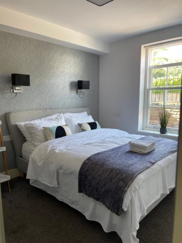 un grande letto bianco in una camera da letto con finestra di Crossbrook street a Cheshunt