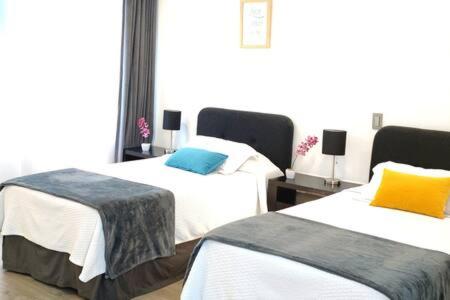a hotel room with two beds and a window at Siqueiros Maia Home - Lujoso apto en Polanco cerca de Antara 3BR in Mexico City