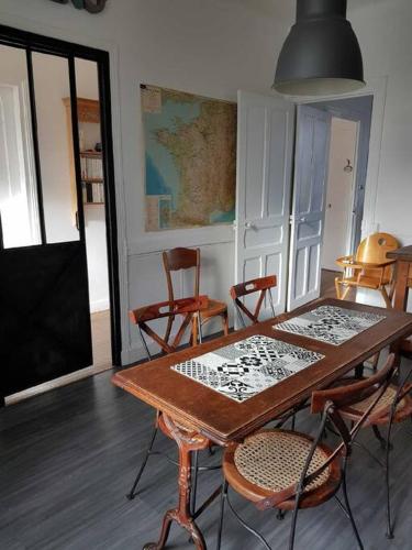 une salle à manger avec une table et des chaises en bois dans l'établissement L'APPART de 75 m², déco sympa à Tours, à Tours