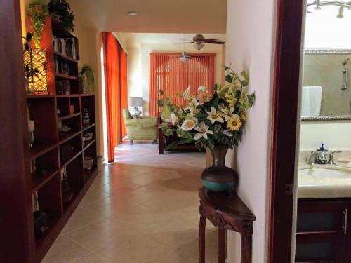 a vase of flowers sitting on a table in a bathroom at Casa Beard, Spacious Guest House with High Speed WiFi & Pool. in Playa del Carmen