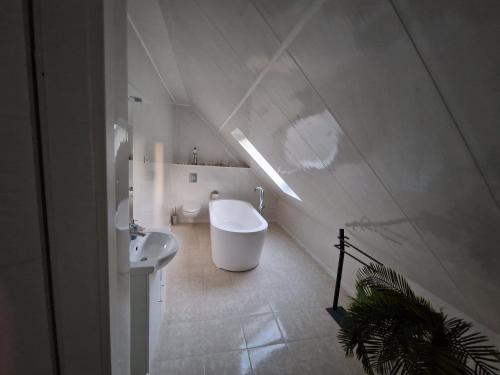 a white bathroom with a sink and a tub at Harmonie, an der Nordküste in Nordenham