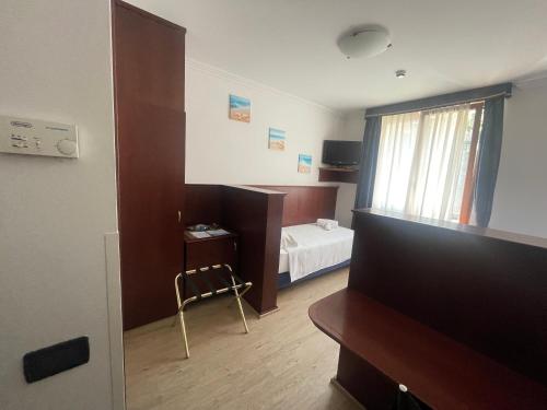 a room with a bedroom with a bed and a television at Panorama Hotel in Muggia